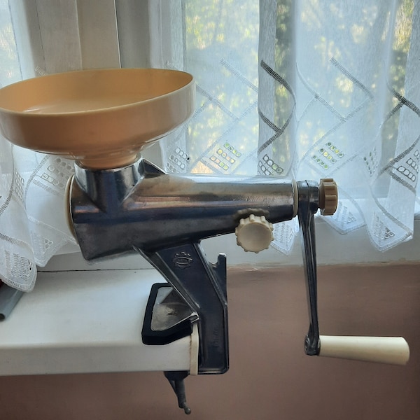 Retro manual juicer for fruits and vegetables. kitchen utensils. Mechanical, desktop grinder for juices or purées. Russian aluminum mill