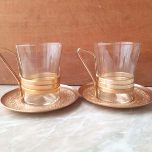金属製スタンド付きのヴィンテージガラス製ティーカップ。カップ付きティーホルダー 2 個セット。お茶好きの方へのギフト。