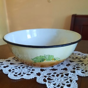 Retro large enamel bowl with flowers. Vintage kitchen enamelware. Camping equipment, rustic kitchen decoration