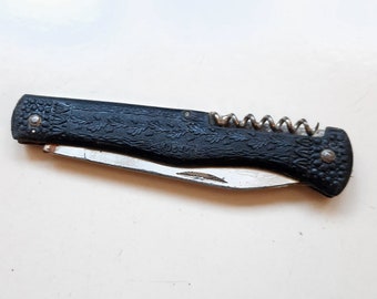 Old small folding knife. Pocket knife for cutting paper and corkscrew for opening bottles with corks.