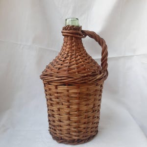 Vintage demijohn with woven cover, rustic mid-century glass wine bottle, demijohn with handle, and demijohn with hand-woven wicker lid