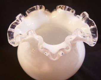 May include: A white milk glass vase with a ruffled edge and silver trim.