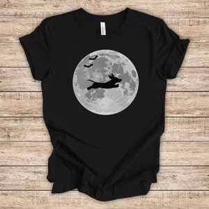 May include: Black t-shirt with a silhouette of a dachshund jumping in front of a full moon with bats flying overhead.