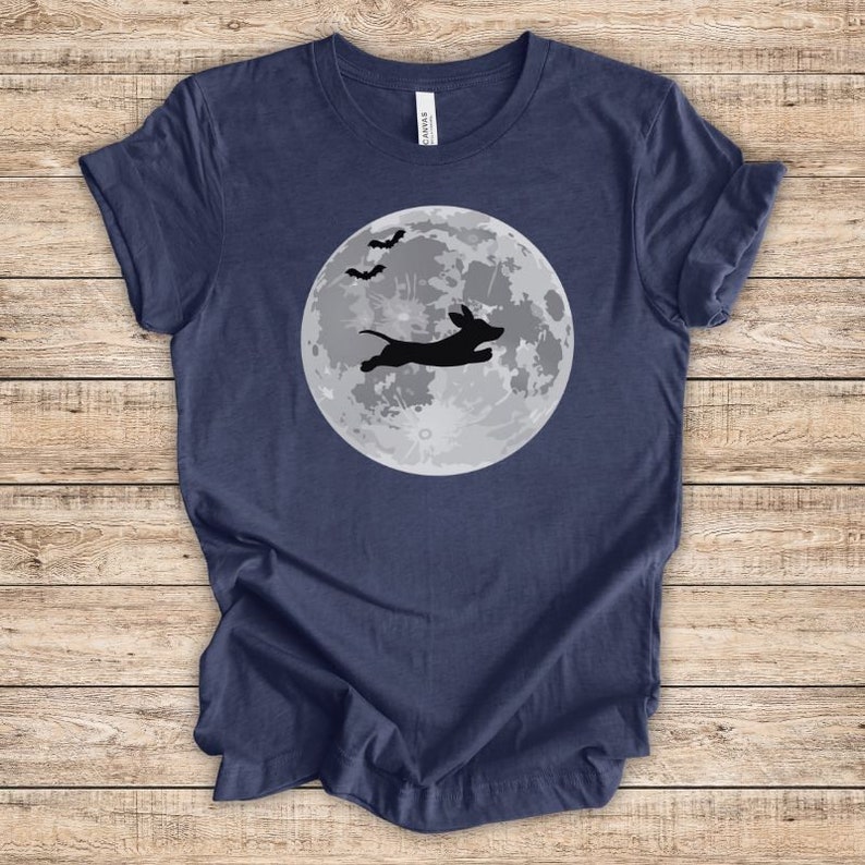 May include: A navy blue t-shirt with a silhouette of a dachshund jumping in front of a full moon with bats flying above.