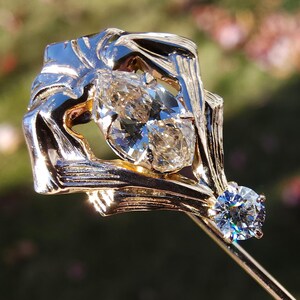 Op de afbeelding: Een gouden en zilveren ring met twee peervormige diamanten. De diamanten zijn gezet in een uniek, abstract ontwerp.