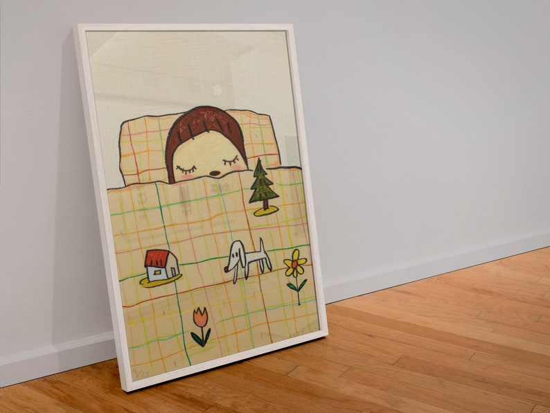 May include: A framed illustration of a girl sleeping in a bed with a checkered blanket. The girl has brown hair and is wearing a white shirt. There are small drawings of a house, a dog, a flower, and a tree on the blanket.