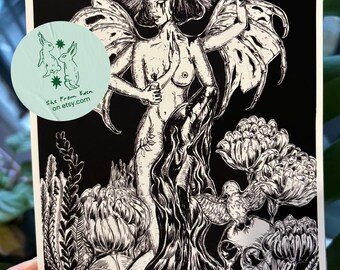 May include: Black and white art print featuring a winged figure holding a candle, surrounded by skulls and flowers. A skeletal animal is held aloft. The print includes the text "She From Eden on etsy.com" in a circular logo.