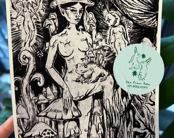 May include: Black and white art print featuring a nude figure with a mushroom cap hat, surrounded by mushrooms and other figures. A frog sits on the figure's lap. The print has the text "She From Eden on etsy.com" on a circular sticker.
