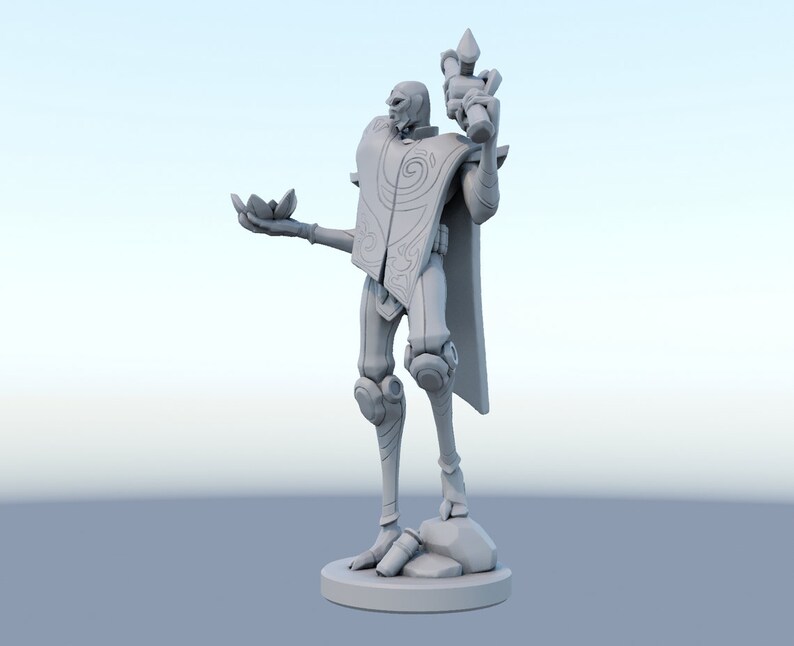 May include: A gray figurine of a humanoid figure with a stylized design. The figure is holding a lotus flower in one hand and a staff in the other. The figure is standing on a round base.