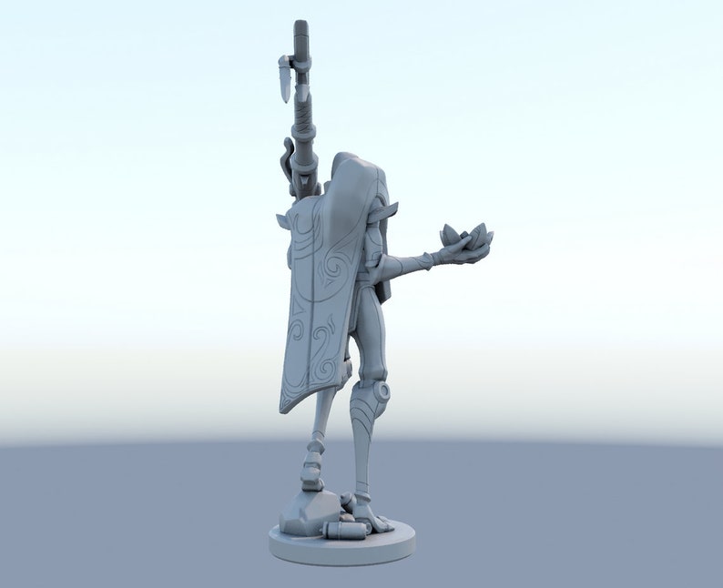 May include: A gray figurine of a character holding a weapon and a lotus flower. The figure is wearing a cape with a decorative swirl design. The figurine is standing on a round base.