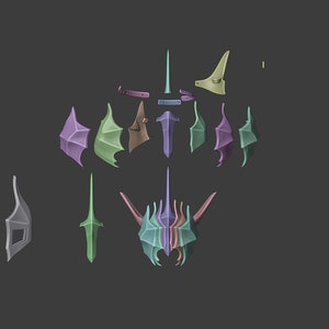 Puede incluir: Un modelo de casco de fantas&iacute;a desmontado con varias piezas en diferentes colores, incluyendo morado, verde y marr&oacute;n. Las piezas est&aacute;n dispuestas sobre un fondo gris.