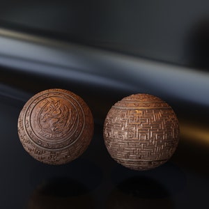 May include: Two decorative spheres with intricate carvings. One sphere features a circular design with a central motif, while the other sphere has a geometric pattern.