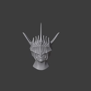 Puede incluir: Un modelo impreso en 3D de un casco con una corona puntiaguda y detalles intrincados. El casco es gris y tiene un dise&ntilde;o afilado y angular.
