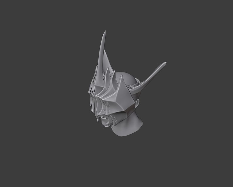 Puede incluir: Un modelo impreso en 3D de un casco con un dise&ntilde;o afilado y angular. El casco est&aacute; hecho de un material gris y tiene una corona puntiaguda y una m&aacute;scara facial con detalles intrincados.