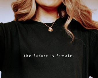 May include: Black t-shirt featuring the white text "the future is female." The garment is a relaxed fit, possibly made from cotton. The design is a bold statement.