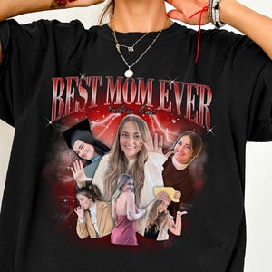 May include: Black t-shirt with the text "BEST MOM EVER" in red and white, with a collage of photos of a woman. The shirt is a crew neck and has short sleeves. The design is centered on the front of the shirt.
