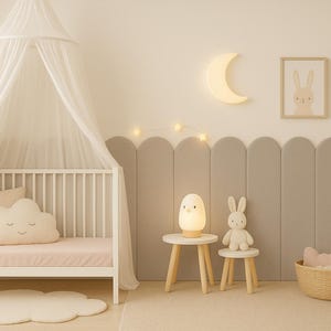 Pode incluir: Um quarto de crian&ccedil;a com um ber&ccedil;o branco, uma almofada em forma de nuvem e um dossel. O quarto apresenta uma luz em forma de lua, obras de arte emolduradas, uma l&acirc;mpada e um brinquedo de coelho em pequenas mesas. Um tapete de nuvem est&aacute; no ch&atilde;o.