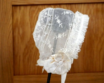 An Antique Machine Embroidered  Organdy Baby Bonnet or Cap with Silk Ribbon Bows