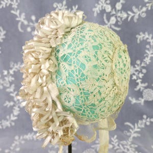 An Antique Victorian Handmade Honiton Lace Baby Bonnet or Cap with Silk Ribbon Bows