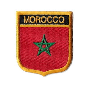 May include: A red, gold, and green embroidered patch with the word "MOROCCO" in gold lettering on a black background. The patch features a green five-pointed star on a red background.