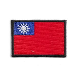 Peut inclure: Écusson brodé représentant le drapeau de Taïwan. Le design comprend un fond rouge avec un canton bleu dans le coin supérieur gauche, contenant un soleil blanc à douze rayons. L'écusson est bordé d'un liseré noir.