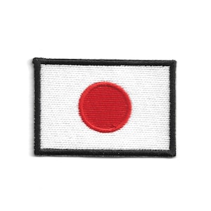 Könnte beinhalten: Gestickter Aufnäher mit der Flagge Japans. Der rechteckige Aufnäher hat einen weißen Hintergrund mit einem zentrierten roten Kreis und einem schwarzen Rand. Geeignet für Kleidung oder Accessoires.