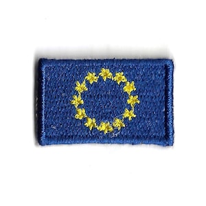 Peut inclure: Un patch brodé bleu avec un cercle d'étoiles jaunes, représentant le drapeau de l'Union européenne.
