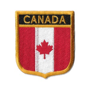 May include: A red and white Canadian flag patch with a gold border and the word "CANADA" in black lettering.
