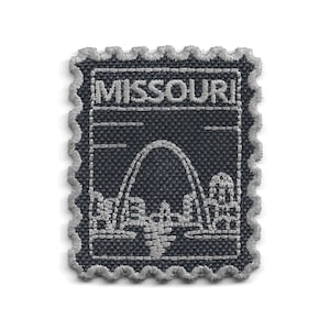 以下が含まれることがあります： 「MISSOURI」の文字が上部に刺繍された、切手型の刺繍パッチ。デザインは、アーチと都市景観をグレーのステッチで表現し、濃いグレーの背景にグレーのスカラップボーダーが施されています。