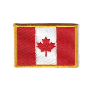 Puede incluir: Parche bordado con la bandera de Canadá. El diseño presenta una hoja de arce roja sobre un fondo blanco, flanqueada por dos franjas verticales rojas. El parche tiene un borde dorado.