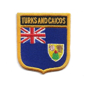 May include: Embroidered patch featuring the flag of Turks and Caicos. The patch has a blue background with the Union Jack in the upper left corner and a coat of arms in the lower right. The text "TURKS AND CAICOS" is embroidered in gold.