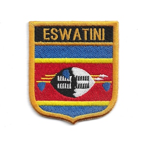 Op de afbeelding: Geborduurde patch met de vlag van Eswatini. De patch heeft een schildvorm met een gouden rand en toont het woord "ESWATINI" in goud op een zwarte achtergrond. Daaronder bevinden zich blauwe en rode strepen met een centraal embleem.