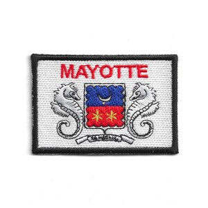 Puede incluir: Parche bordado con la palabra "MAYOTTE" en rojo. Presenta un escudo con elementos azules y rojos, flanqueado por dos caballitos de mar. Fondo blanco y borde negro.