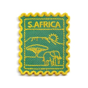 May include: A rectangular embroidered patch with a scalloped yellow border on a green background. The design features yellow stitching depicting a landscape with a sun, a tree, an elephant, and the text S. AFRICA at the top of the patch.