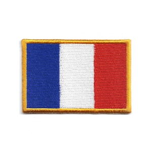 Peut inclure: Écusson brodé représentant le drapeau français, un tricolore vertical bleu, blanc et rouge. L'écusson rectangulaire a une bordure dorée. Les couleurs sont vives et la couture est détaillée, créant un aspect texturé.
