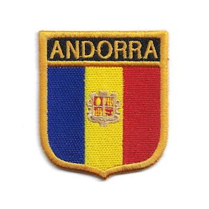 May include: Embroidered patch featuring the word "ANDORRA" in black on a gold border. The patch displays the Andorran flag with vertical stripes of blue, yellow, and red, and the coat of arms in the center.