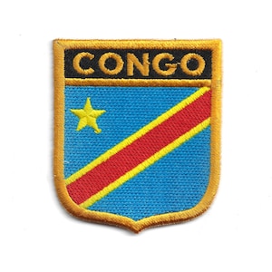 May include: Embroidered patch featuring the word "CONGO" in gold lettering above a shield design. The shield has a blue background with a yellow star and a red and yellow diagonal stripe. The patch has a gold border.