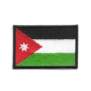 Op de afbeelding: Geborduurde patch met de vlag van Jordanië. De rechthoekige patch heeft een zwarte rand en toont het ontwerp van de vlag: een rode driehoek met een witte ster, en zwarte, witte en groene horizontale strepen.