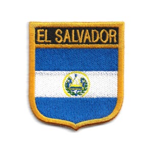 May include: Embroidered patch featuring the flag of El Salvador. The patch has a shield shape with a gold border. The flag design includes blue and white horizontal stripes and a central emblem.