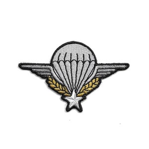 May include: A silver embroidered patch featuring a parachute, wings, and a star. The parachute is surrounded by two golden wheat stalks.