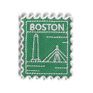 Peut inclure: Un écusson en tissu vert avec des détails brodés en blanc. L'écusson porte le mot "BOSTON" en haut et une représentation d'un monument et d'un pont. L'écusson a une bordure blanche festonnée, ressemblant à un timbre-poste.