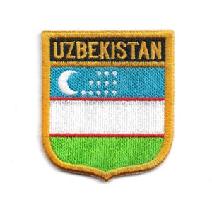 May include: Embroidered patch of the Uzbekistan flag. The patch has a gold border and a shield shape. The flag design includes a crescent moon and stars on a blue stripe, a white stripe, and a green stripe. The word "UZBEKISTAN" is embroidered at the top.