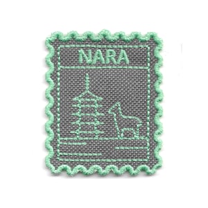 Op de afbeelding: Een grijs geborduurd embleem met een geschulpte mintgroene rand. De patch heeft het woord "NARA" bovenaan, met een afbeelding van een pagode en een hert in het midden. Het ontwerp is gestikt in mintgroen garen.