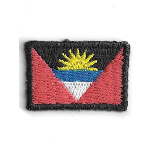 May include: Embroidered patch featuring the flag of Antigua and Barbuda. The design includes a yellow sun, blue and white stripes, and red triangles on a black background. The patch is rectangular with a black border.