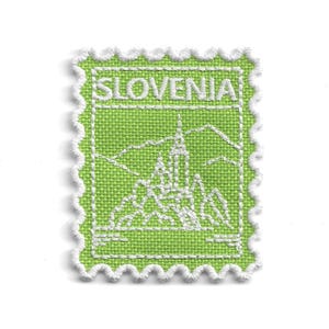 May include: A rectangular embroidered patch in lime green with a white scalloped border. The design features white stitching depicting a landscape with a church and mountains, with the word SLOVENIA embroidered in white at the top of the patch.