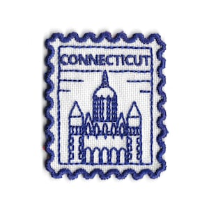 Könnte beinhalten: Eine weiße Keramik-Tasse mit schwarzem Henkel und dem Text "But First, Coffee" in schwarzer, handschriftlicher Schrift. Die Tasse steht auf einer weißen Oberfläche.