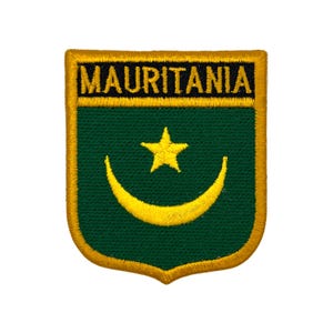 May include: Embroidered patch featuring the word "MAURITANIA" in gold lettering above a green shield. The shield displays a gold crescent moon and star, with a gold border.