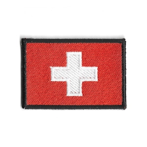 Pode incluir: Patch bordado com a bandeira suíça. O patch tem um fundo vermelho com uma cruz branca no centro. As bordas são bordadas com costuras pretas. Adequado para jaquetas, bolsas ou outros artigos de tecido.