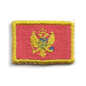 May include: Embroidered patch featuring the flag of Montenegro. The patch has a red background with a gold border. The center displays a gold double-headed eagle with a shield and crown, with blue and yellow accents.