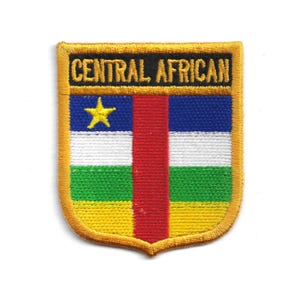 May include: A shield-shaped patch with the text "CENTRAL AFRICAN" at the top. The patch features the Central African Republic flag design: a blue stripe with a yellow star, a red vertical stripe, and horizontal stripes of white, green, and yellow.